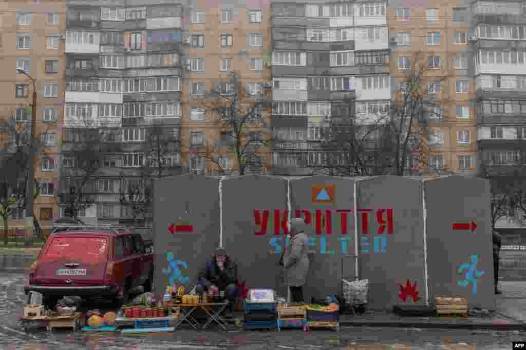 People sell vegetables and other goods next to a bomb shelter at a market in Kramatorsk, Donetsk region, amid the Russian invasion of Ukraine.