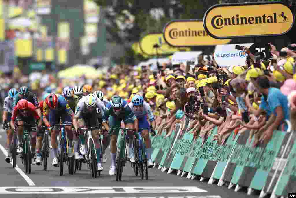 Alpecin-Deceuninck's Belgian rider Jasper Philipsen (2nd R) sprints to the finish line ahead of Team Jayco Alula's Dutch rider Dylan Groenewegen (R) and Bahrain - Victorious' German rider Phil Bauhaus (C) to win the 11th stage of the 110th edition of the Tour de France cycling race, 180 km between Clermont-Ferrand and Moulins, in central France.