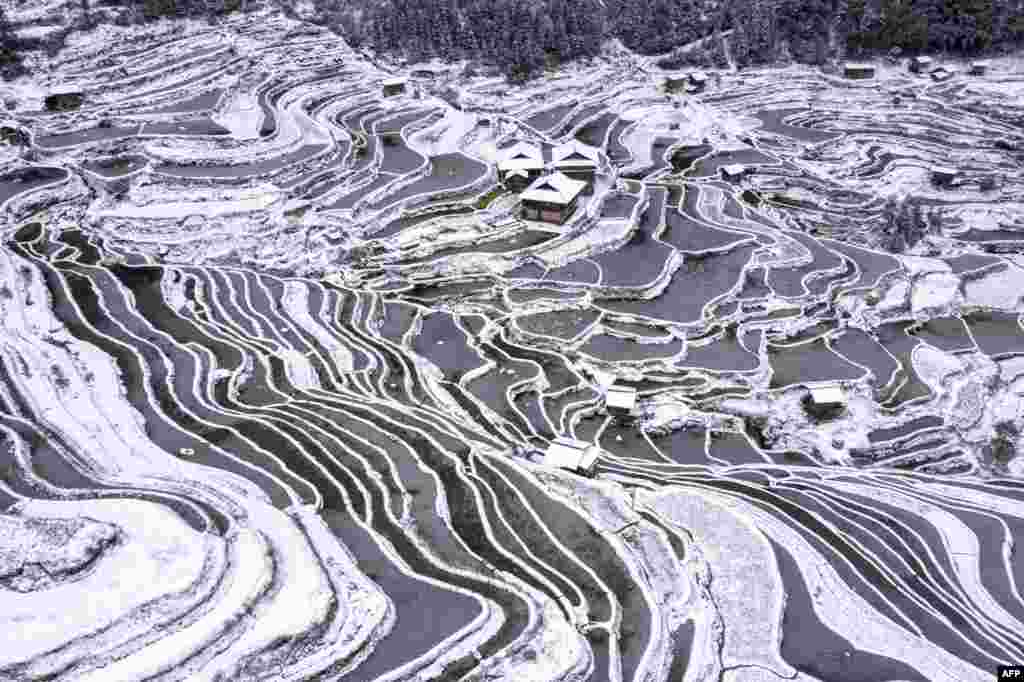 The aerial view shows snow-covered terraced fields and houses in Congjiang county, in China's southwestern Guizhou province.