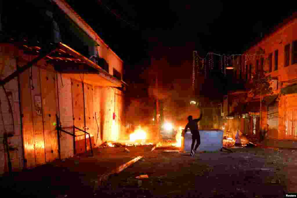 A Palestinian throws stones as the Israeli army raids Ramallah, in the Israeli-occupied West Bank, June 8, 2023.