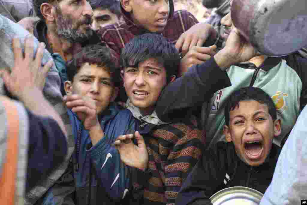Palestinians line up for food in Rafah, Gaza Strip, during a temporary ceasefire between Israel and Hamas.