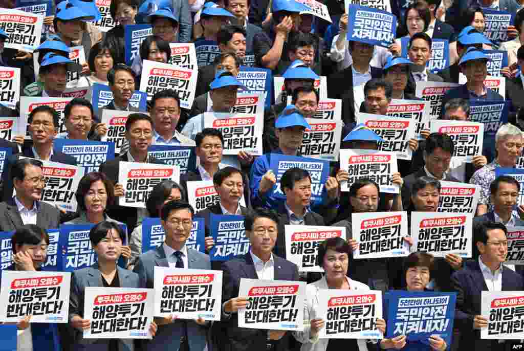 South Korea's main opposition Democratic Party lawmakers and party members hold placards reading "We oppose the dumping of Fukushima contaminated water into the sea" during a rally against Japan's plan to release treated water from the Fukushima nuclear plant, at the National Assembly in Seoul.