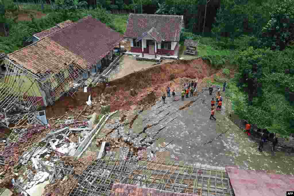 Members of the West Java Regional Disaster Management Agency inspect a school destroyed by a landslide after heavy rains in Bandung, West Java, Indoneisa.
