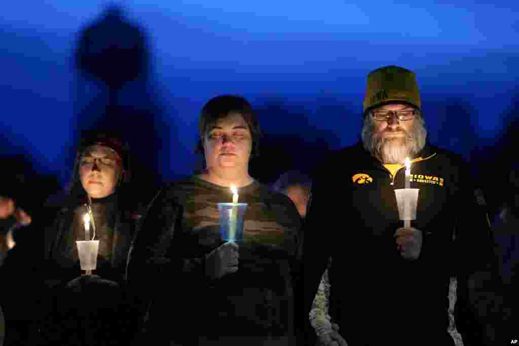 Local residents pray during a candlelight vigil following a shooting at Perry High School, Jan. 4, 2024, in Perry, Iowa