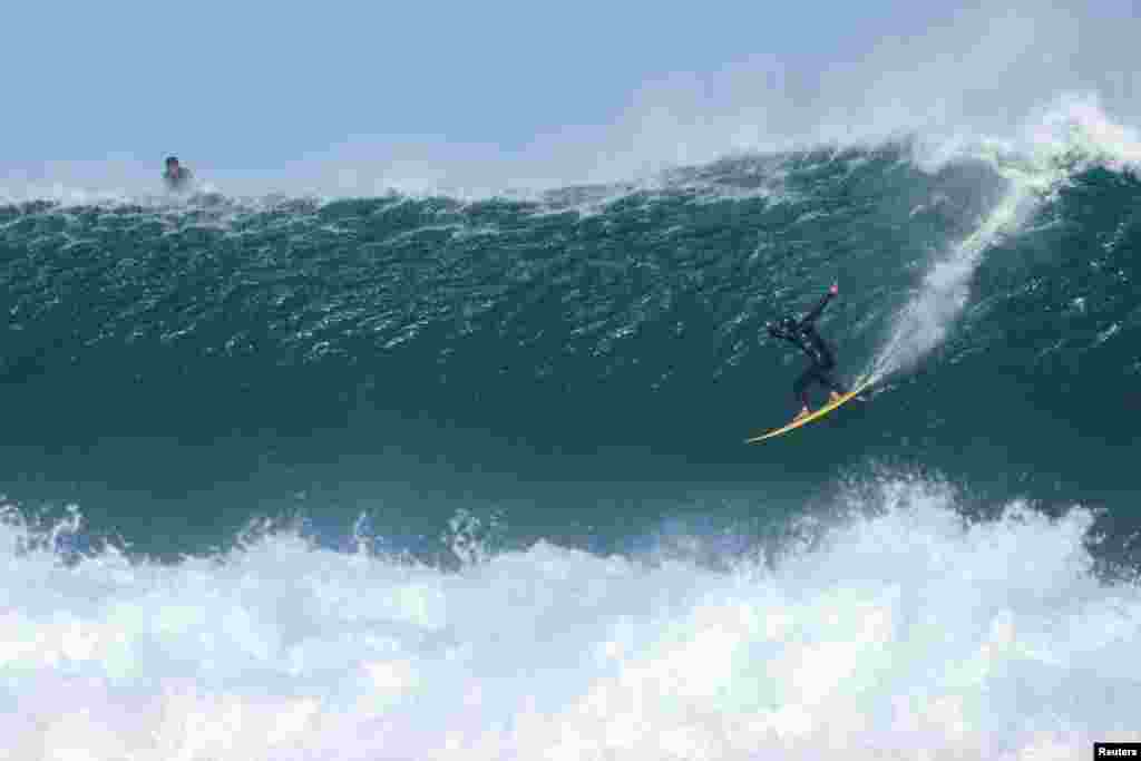 South African big wave surfer Asha Armstrong rides a wave as seasonal cold fronts drive big swells into the Cape Peninsula in Cape Town, South Africa.