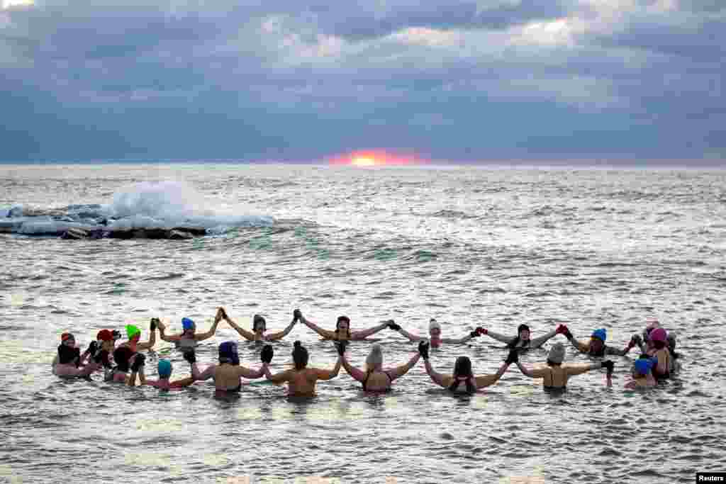 A group consisting mostly of women, who call themselves "The Endorphins," gather for a sunrise swim in the chilly waters of Lake Ontario during freezing temperatures in Toronto, Ontario, Canada.