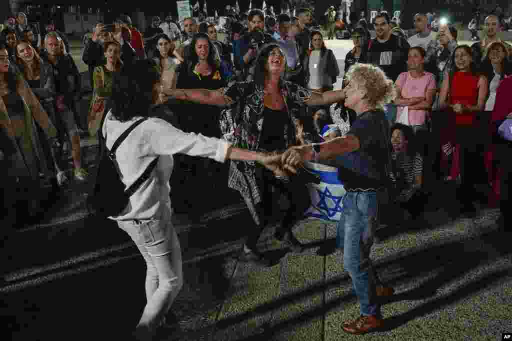 People react as they hear the news of the release of 13 Israeli hostages held by Hamas in the Gaza strip, in Tel Aviv, Israel.