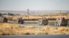 FILE - U.S. military vehicles patrol along a road near the town of Tal Baydar in Syria's northeastern Hasakeh province, Oct. 12, 2019. A one-way drone attack at Tal Baydar in Syria on Nov. 17, 2023, damaged infrastructure at the base and injured a service member.