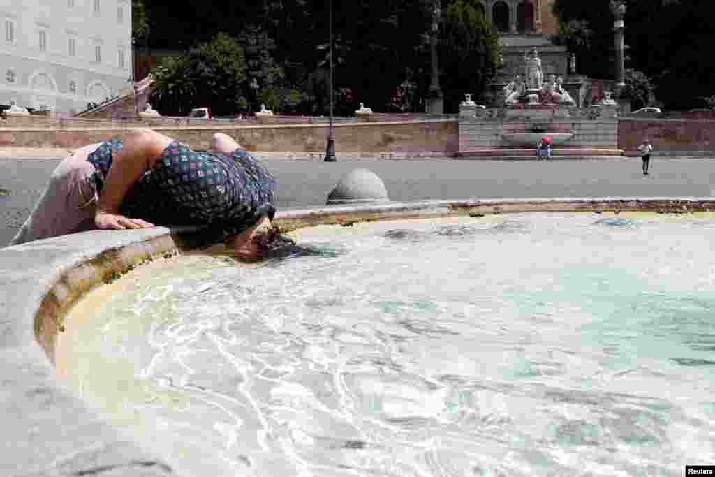 A person cools off at the Piazza del Popolo in Rome during a heatwave across Italy as temperatures are expected to rise further in the coming days.