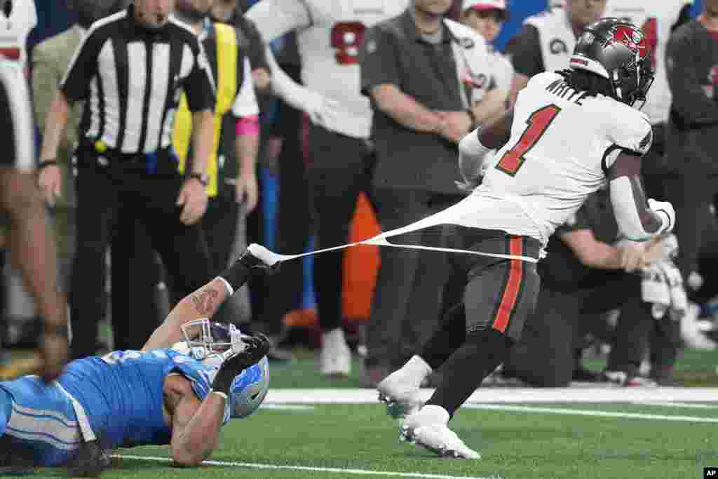 Detroit Lions defensive end Romeo Okwara, left, grabs the jersey of Tampa Bay Buccaneers running back Rachaad White (1) during the second half of an NFL football NFC divisional playoff game, Jan. 21, 2024, in Detroit, Michigan.