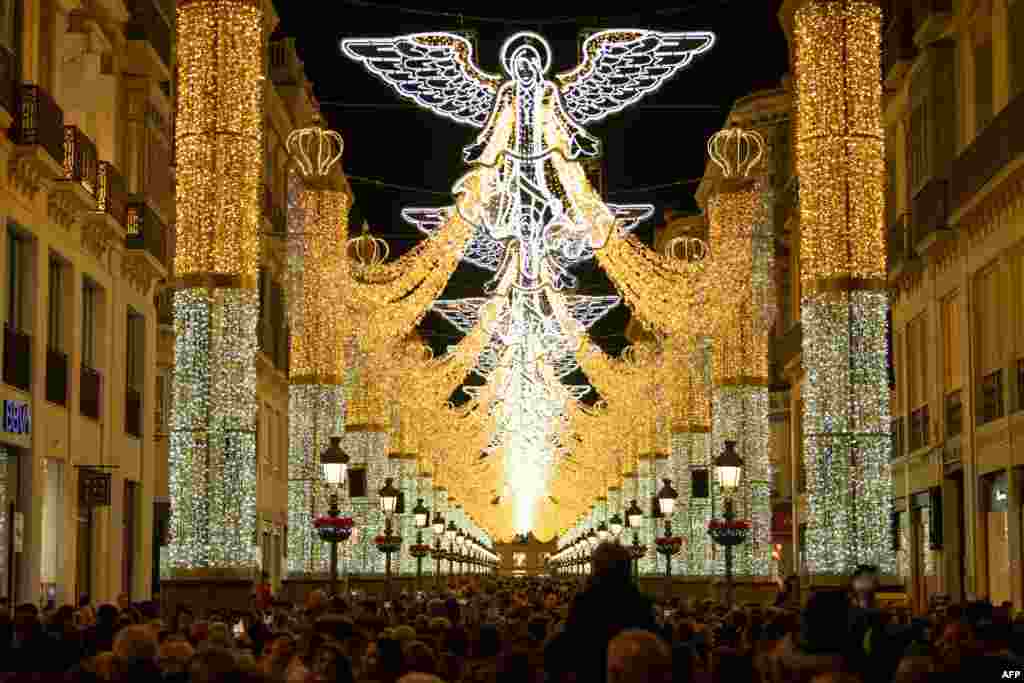 People observe the Christmas lights on Larios street in Malaga, Spain, Dec. 2, 2023.