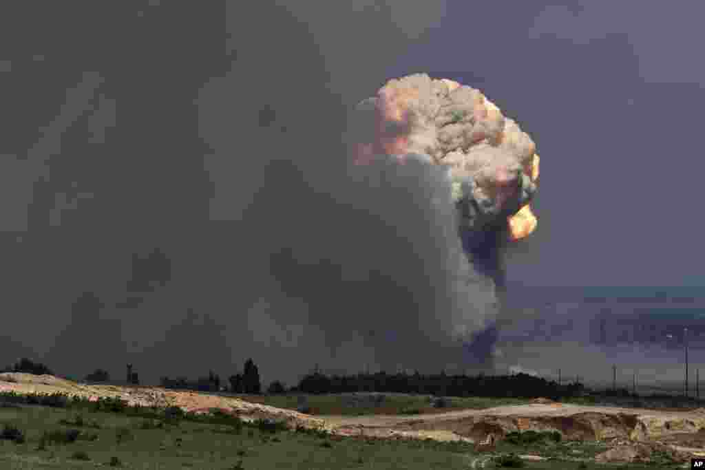 A plume of smoke rises over an ammunition depot where explosions occurred at the facility in Kirovsky district in Crimea. Russian emergency officials in Crimea said more than 2,200 people were evacuated from four villages because of a fire at a military facility. 