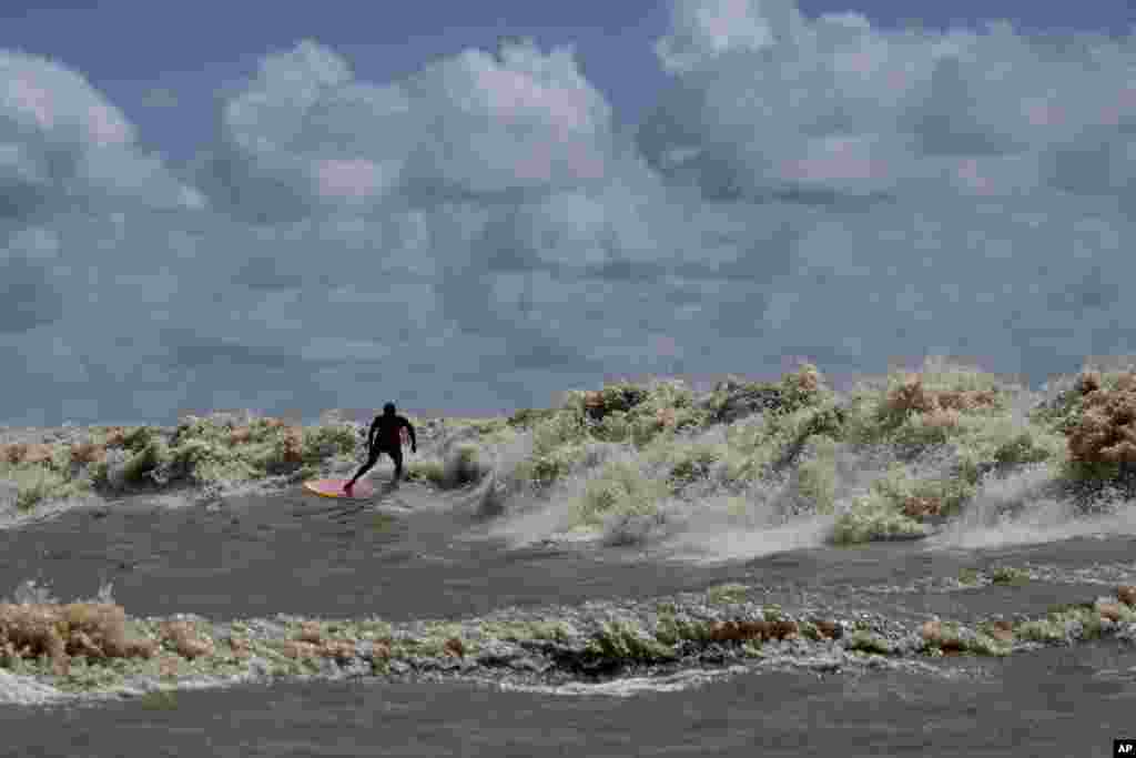 Brazilian surfer Naysson Costa rides the tidal bore wave known as "Pororoca," during the Amazon Surf Festival held in the Canal do Perigoso, or "Dangerous Channel," at the mouth of the Amazon River near Chaves, Marajo Island archipelago, Para state, Brazil, June 5, 2023. T