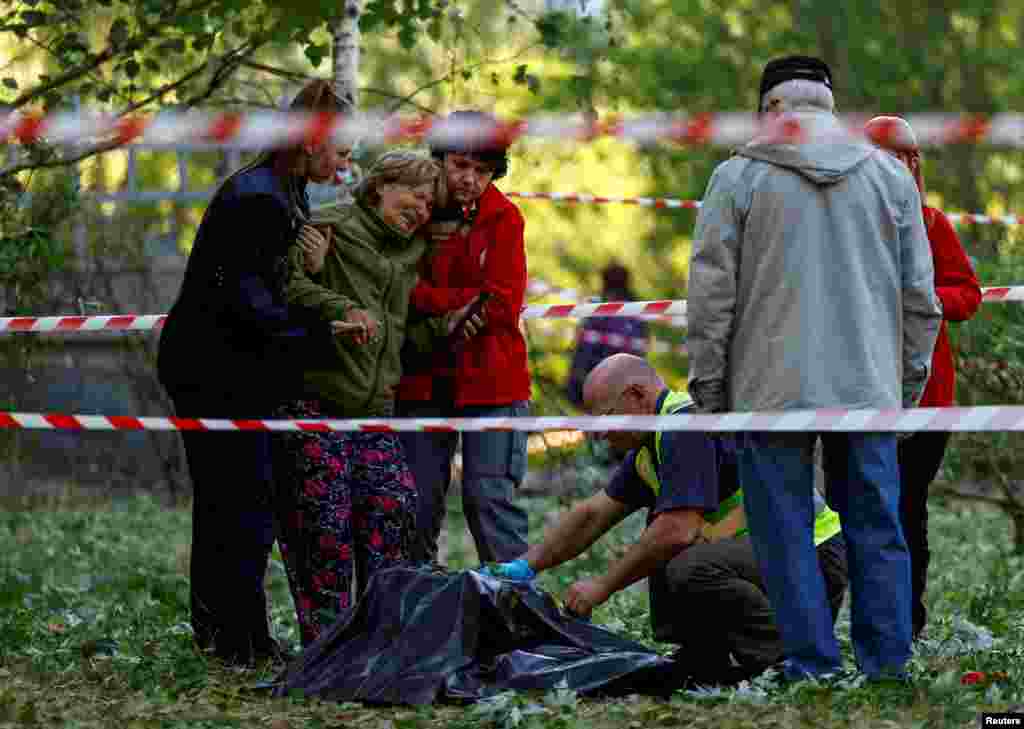 A woman reacts as she looks at the body of her daughter, who was killed during a Russian missile strike, amid Russia's attack on Ukraine, in Kyiv, Ukraine.