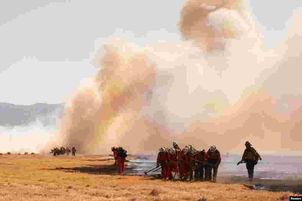 An inmate crew works the line as the Danny Fire burns over 1,500 acres of Lancaster, California, June 4, 2023.
