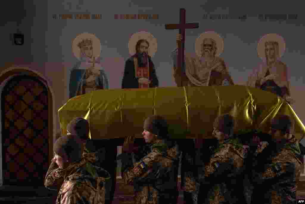 Ukrainian servicemen carry a coffin of a Ukrainian poet and serviceman Maksym Kryvtsov who was killed fighting Russian troops, at the Saint Michael's Golden-Domed Monastery in Kyiv.