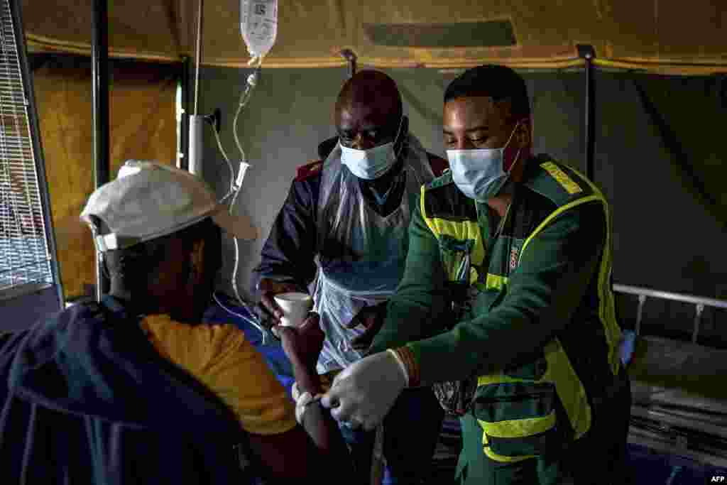 A dehydrated patient is given water as he receives treatment at a field hospital in Kanana, Hammanskraal. An outbreak of cholera has killed at least 23 people near South Africa's capital of Pretoria, as city officials urged residents of Hammanskraal and surrounding areas not to drink from the tap, adding water tankers were being supplied.
