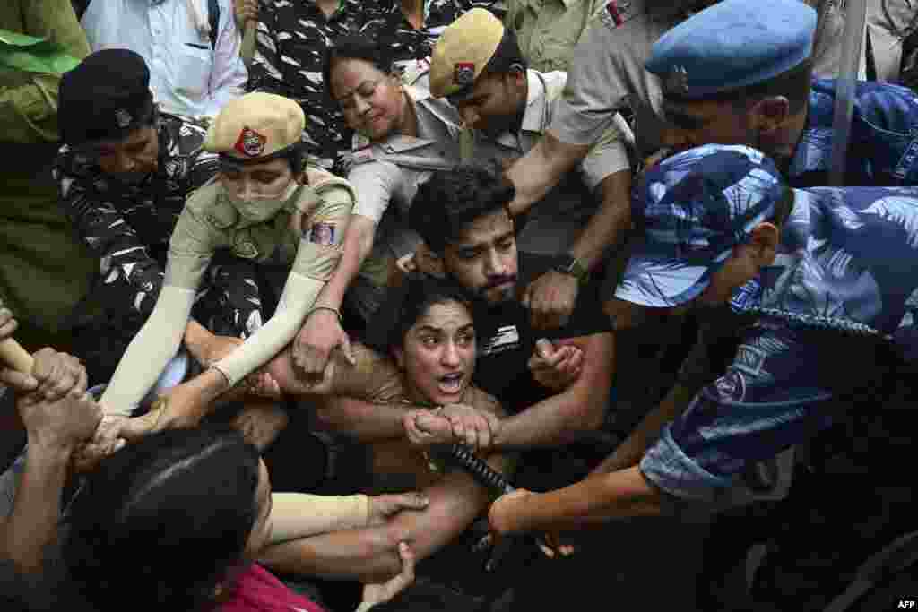 Indian police detain wrestlers Vinesh Phogat (C) with others while attempting to march to India's new parliament, just as it was being inaugurated by Prime Minister Narendra Modi, in New Delh, during a protest against Brij Bhushan Singh, the wrestling federation chief, over allegations of sexual harassment and intimidation.
