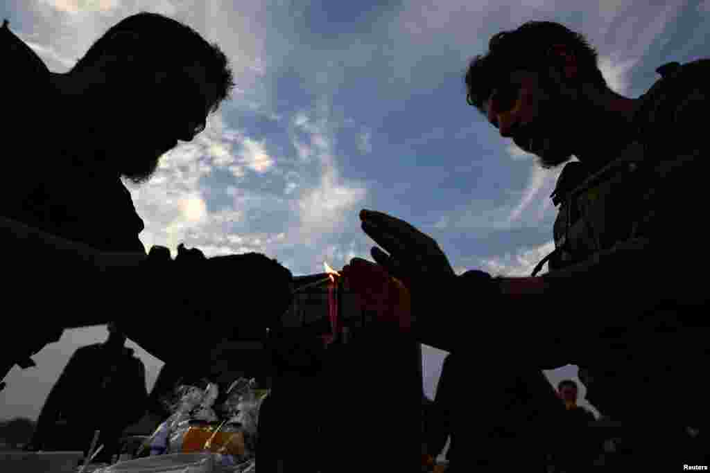 Israeli soldiers light candles to celebrate the Jewish festival of Hanukkah, near the border with the Gaza Strip, amid the ongoing conflict between Israel and the Palestinian Islamist group Hamas, in Beeri, Israel.