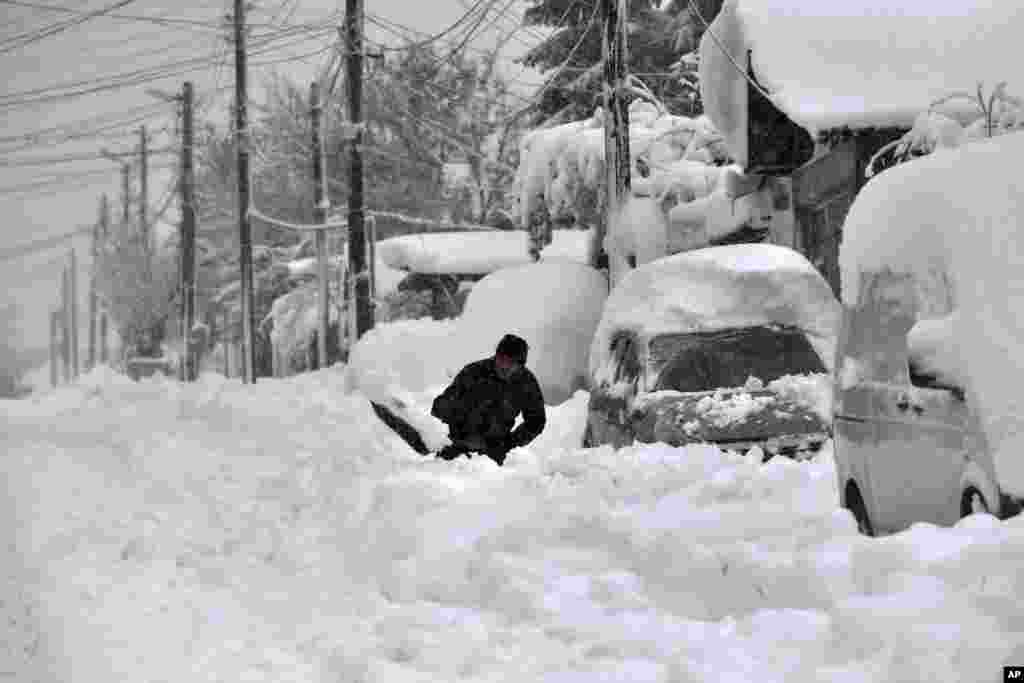 A man shovels snow in Isperih, Northeast Bulgaria. Bulgaria's government declared a state of emergency in large parts of the Balkan country after heavy snow and powerful winds caused power outages, closed roads, traffic accidents and travel delays. 