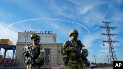 Wanajeshi wa Russia wakiwa wameshika doria nje ya kiwanda cha umeme cha Kakhovka, karibu na mto Dnieper, Kherson, kusini mwa Ukraine. May 20, 2022