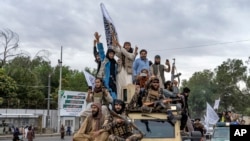 Wapiganaji wa Taliban wakisherehekea mwaka mmoa tangu kuchukua mji mkuu wa Afghanistan Kabul, mbele ya Ubalozi wa Marekani Kabul Afghanistan, Jumatatu Aug. 15, 2022. 