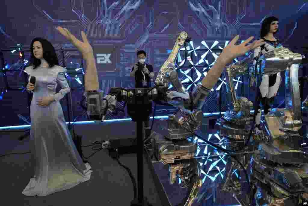 Robots that can sing and wave are shown during the World Robot Conference at the Yichuang International Conference and Exhibition Center in Beijing