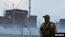 FILE - Mwanajeshi akiwa na bendera ya Russia katika unifomu yake akilinda karibu na Kinu cha Nyuklia cha Zaporizhzhia katika mkoa wa Zaporizhzhia region, Ukraine, Aug. 4, 2022. 