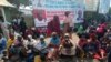 Protesters sit on the ground in front of the National Assembly gate after hours of demonstrations over gender bills by lawmakers in Abuja, Nigeria, March 2, 2022. (Timothy Obiezu/VOA) 