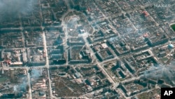 Imaj satelit sa a ke Maxar Technologies pran Lendi 21 Mas 2022 montre sant Dramatik Mariupol la (anwo fe mitan an) ak zon alantou li ki andomaje nan Mariupol, Ikren.