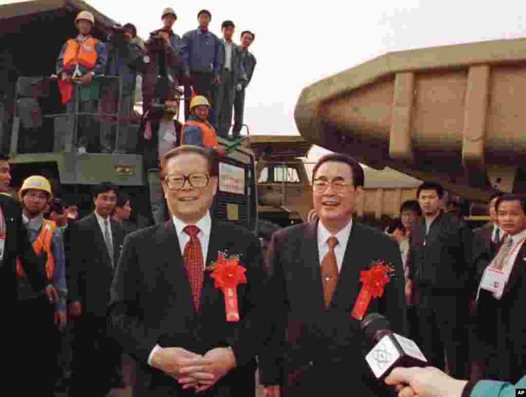 1997年11月8日,三峡工程大江截流成功,中国主席江泽民和总理李鹏(右)在三峡工程工地祝贺职工们。和这形成对比的是,2005 年5月20日,三峡大坝建成和封顶,中央领导全体缺席庆典,对三峡大坝情有独钟的李鹏也没露面。庆典只持续了八分钟,中央电视台没有转播实况。 >