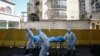 Medical workers move a person who died from COVID-19 at a hospital in Wuhan in central China's Hubei province, Feb. 16, 2020.