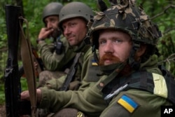 Wanajeshi wa Ukraine wakipumzika katika kijiji walichokikomboa hivi karibuni kaskazini ya Kharkiv, mashariki ya Ukraine, Mei 15, 2022