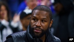 FILE - Boxer Floyd Joy Mayweather Jr. looks on during Game 1 of an NBA basketball first-round playoff series between the Toronto Raptors and the Philadelphia 76ers, Apr. 16, 2022, in Philadelphia.
