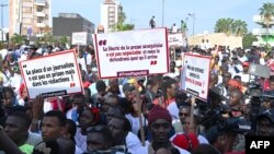 FILE - Senegalese journalists hold banners and shout slogans during the march for the release of their colleague Pape Ale Niang in Dakar, Nov. 18, 2022.