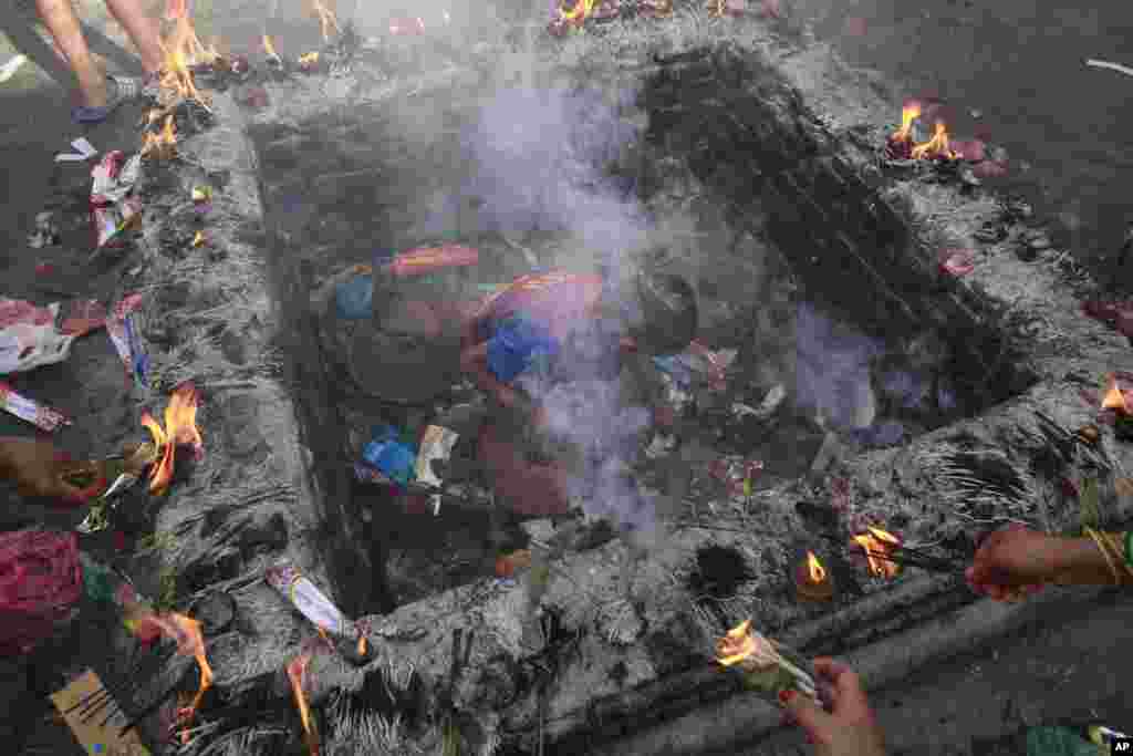 Seorang anak laki-laki mencari mata uang logam (koin) yang dilemparkan warga Hindu di sebuah kuil di Kathmandu, Nepal.