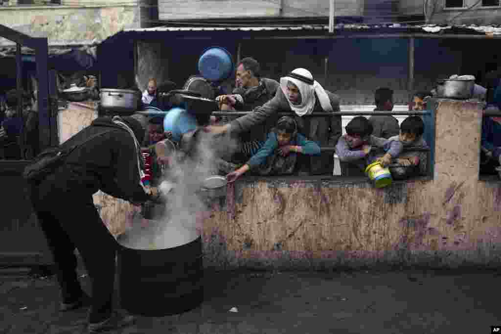 Palestinians line up for a free meal in Rafah, Gaza Strip. International aid agencies say Gaza is suffering from shortages of food, medicine and other basic supplies as a result of the war between Israel and Hamas.