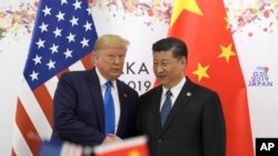 FILE - President Donald Trump poses for a photo with Chinese President Xi Jinping during a meeting on the sidelines of the G-20 summit in Osaka, Japan, June 29, 2019. 