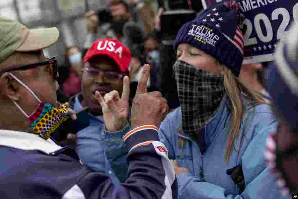 U.S. President Donald Trump's supporters, right, argues with a counter protester, left, as they protest election results outside the central counting board at the TCF Center in Detroit, Michigan.