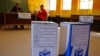 Ballot boxes await voters as Election officials (background) await their arrival after they opened early for disabled people to vote in Nyanga township before Wednesdays official elections on the outskirts of the city of Cape Town, South Africa, May 5, 2