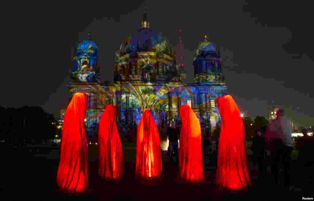 Warga setempat mengamati pemasangan lampu di Gereja Katedra, Berlin, yang menandai dimulainya Festival Cahaya "Festival of Light" di Berlin, 9 Oktober 2013.