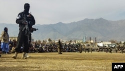 Afisa wa usalama wa Taliban akiwa ameshika doria wakati wa watu wanaodaiwa kufanya makosa mbalimbali walipokuwa wanapigwa viboko katika mjiwa Charikar, December 8, 2022