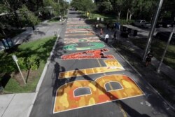 Several local artists painted Black Live Matter mural on the street during a Juneteenth 2020 celebration outside the Dr. Carter G. Woodson African American Museum Friday, June 19, 2020, in St. Petersburg, Fla.