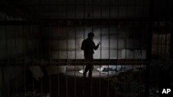 Украинский военный осматривает подвальное помещение, которое, по данным следственных органов Украины, использовалось как камера пыток в период российской оккупации. Казачья Лопань, Харьковская область (архивное фото)