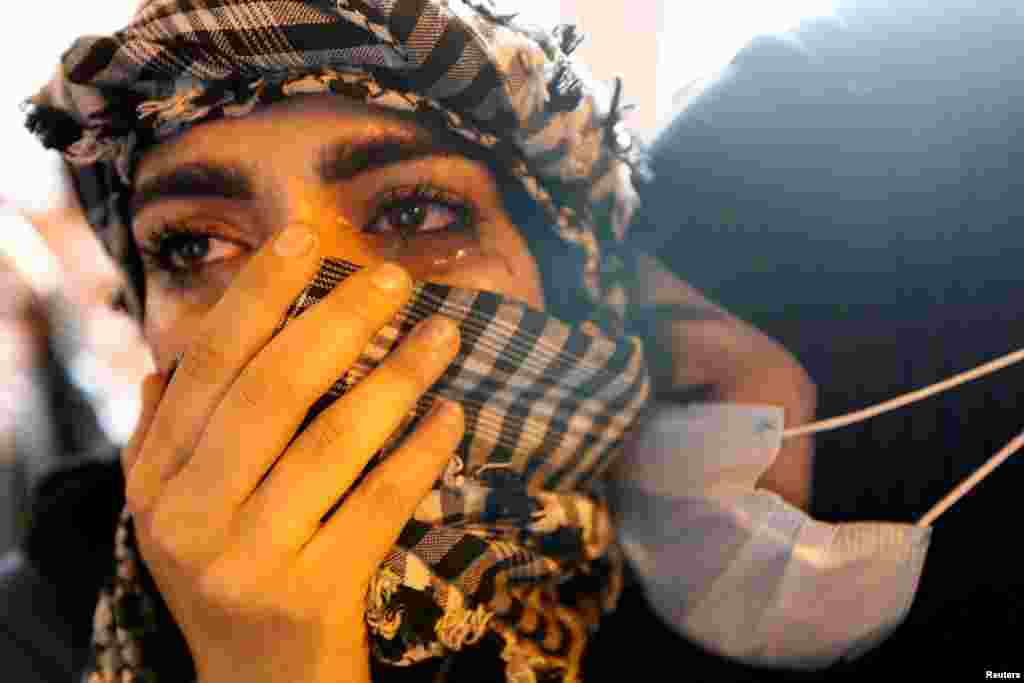 Iraqi demonstrators react as they gather to mark the first anniversary of the anti-government protests in Baghdad.