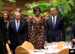 FILE - President Barack Obama, right, and first lady Michelle arrive for a state dinner with Cuba's President Raul Castro, left, at the Palace of the Revolution in Havana, March 21, 2016.