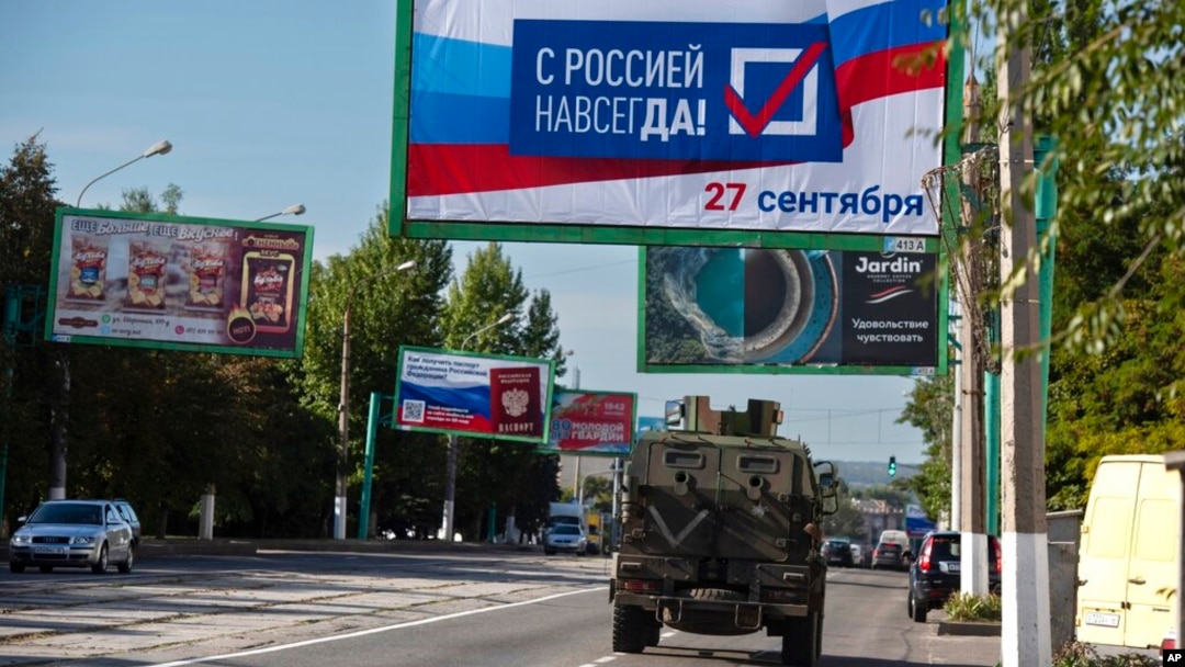 Rusko vojno vozilo prolazi ulicom pored bilborda na kom piše "Sa Rusijom zauvek, 27. septembar", pred referendum u Lugansku, teritoriji pod kontrolom proruskih separatista, u ističnoj Ukrajini, 22. septembra 2022.