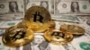 FILE - Representations of virtual currency Bitcoin are placed on U.S. Dollar banknotes in this illustration taken May 26, 2020. 