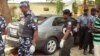 Policemen stand at the scene of a bomb blast at the public health college in northern Nigerian city of Kano, June 23, 2014.