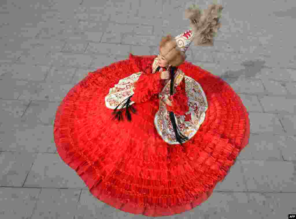 A woman wearing a traditional costume attends the celebrations marking the National Flag Day and the Day of Kyrgyz national "Ak-kalpak" hat at the central Ala-Too Square in Bishkek.
